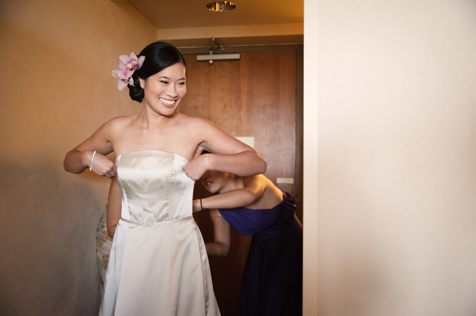 Bridesmaid helping Bride into Dress