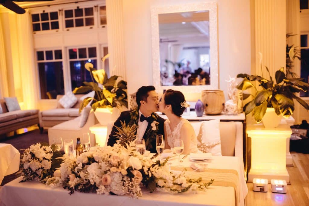Bride and Groom kissing at Sweetheart table at Moana Grand Salon