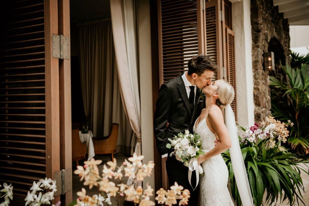 Groom kissing Bride in front of Halekulani Tea Room