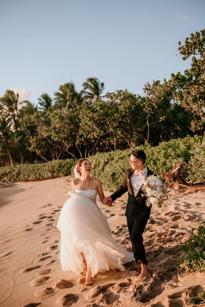 Bride and Groom running on beach Lanikuhonua Phase 3