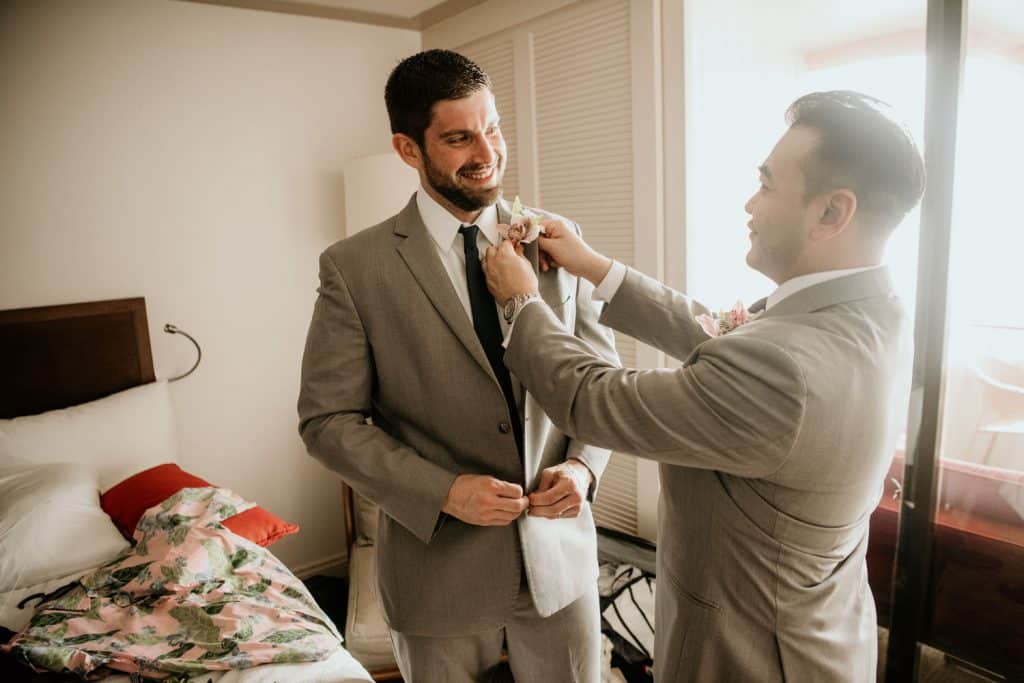 Groomsmen helping each other put on bow ties