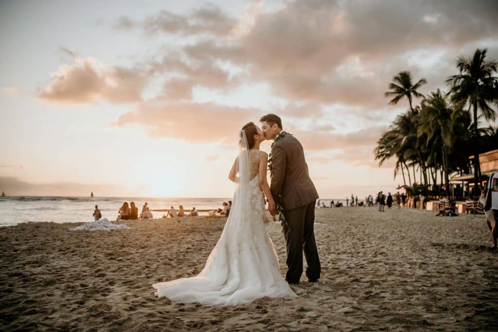 Bride & Groom kiss on Waikiki Beach as sun sets