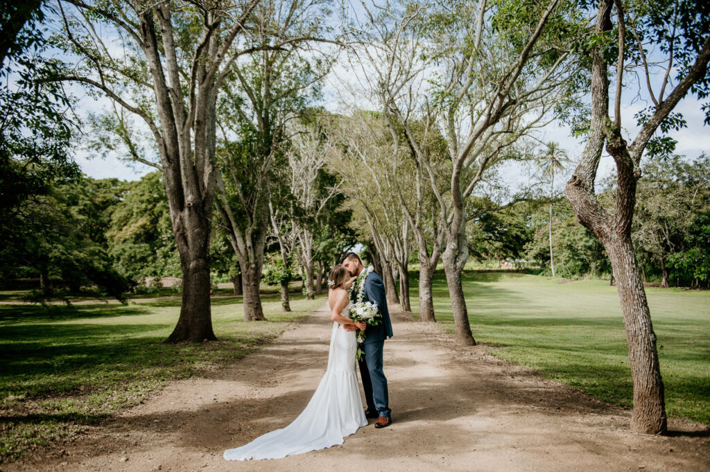 Bride and groom in between row of trees at Dilllingham Ranch