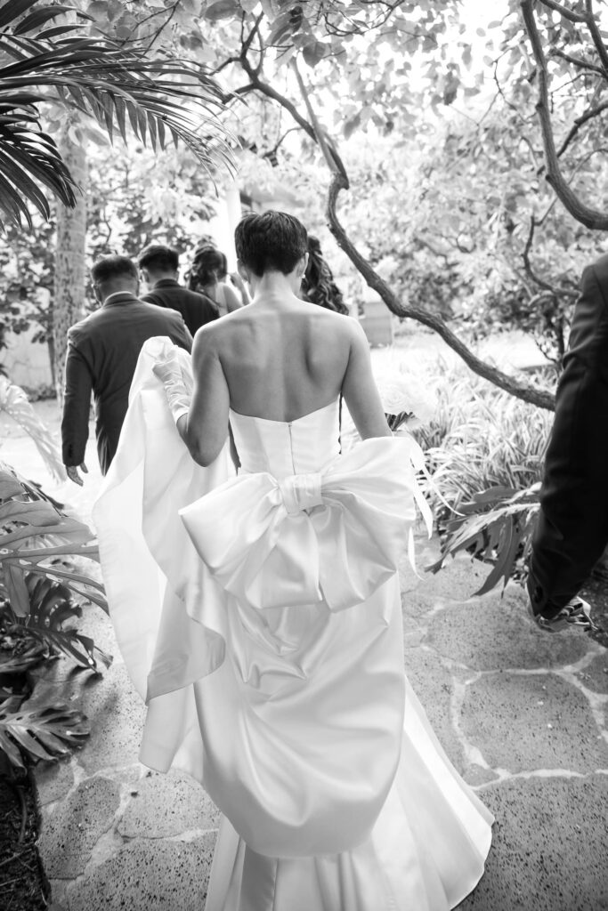 Black and White image of bride walking with couture wedding dress.