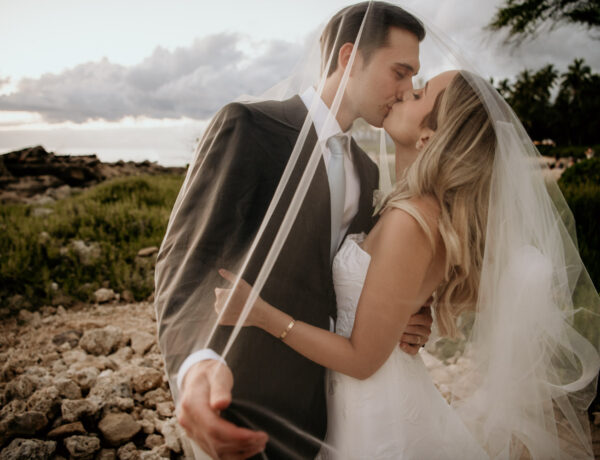 Bride and groom kissing Four Seasons Oahu Secret Beach Wedding.