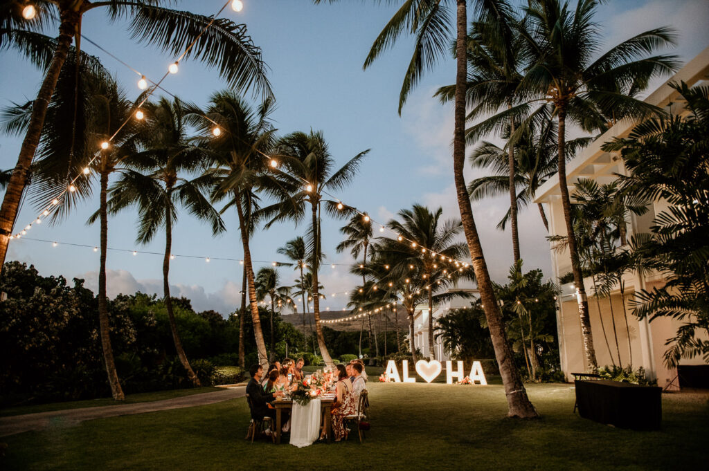 Dusk at Lurline Lawn with Aloha Sign and wedding reception table.