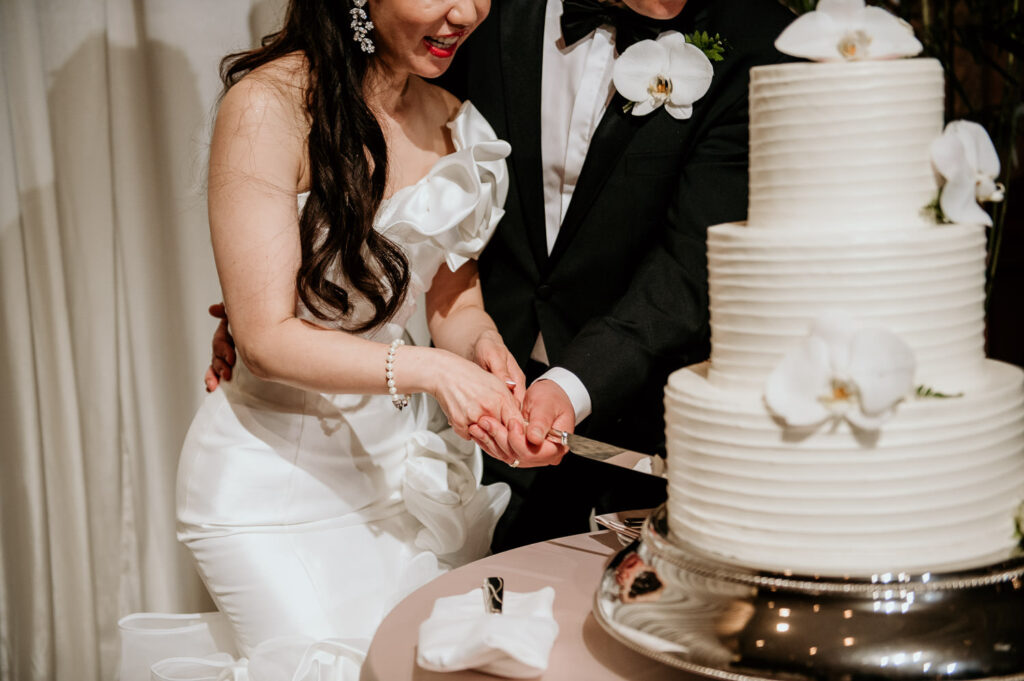 Close up of Bride and Groom cutting the wedding cake at Halekulani Ballroom.