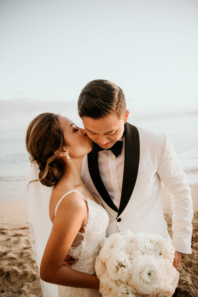 Modern Wedding Photographer captures bride and groom kissing on Waikiki Beach