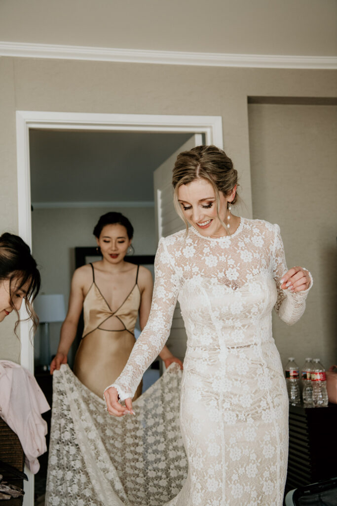Bride getting into her dress in the hotel suite at the Moana Surfrider.