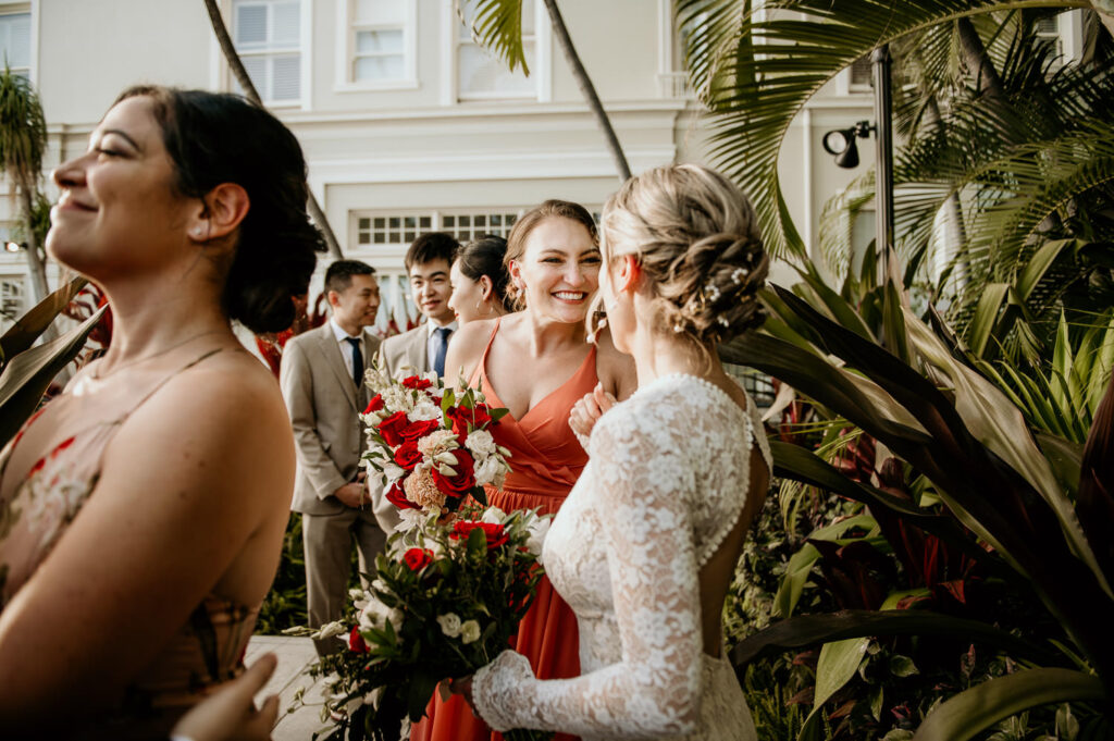 Friends embrace bride at the wedding ceremony at the Moana Surfrider.