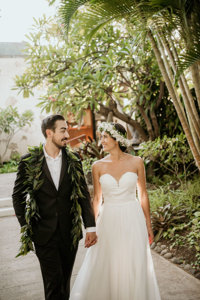 Bride and Groom walking at Outrigger Canoe Club Entrance